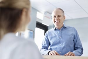 A man smiling at a dental employee.