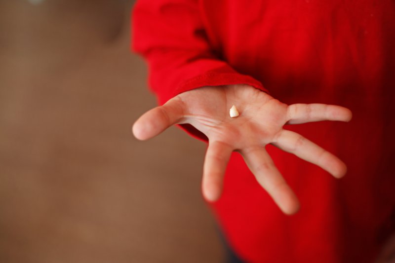 A person holding a knocked out tooth in Saratoga.