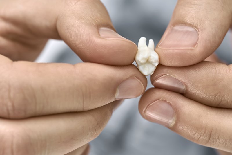 Holding a lost tooth with two hands