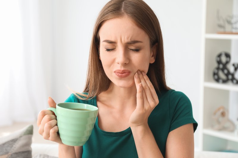 Woman with tooth pain rubbing her cheek