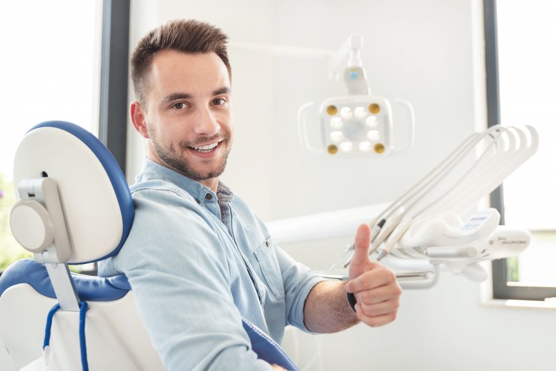 Male dental patient giving a thumbs up